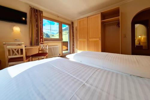 a bedroom with a large white bed and a window at Haus Tirol in Tux