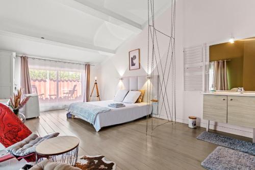 a bedroom with a bed and a table in a room at Mas J des Sens - petit dej compris in Le Val