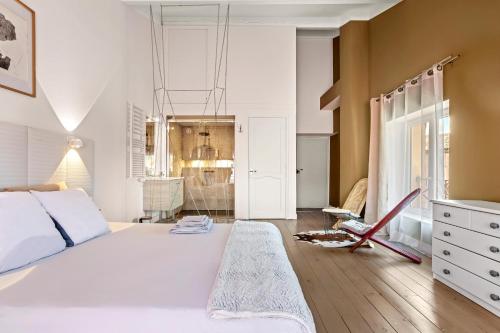 a bedroom with a large white bed and a mirror at Mas J des Sens - petit dej compris in Le Val