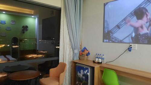 a living room with a flat screen tv on a wall at NEST House in Ấp Kim Thạch