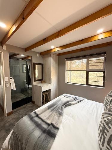 a bedroom with a large bed and a bathroom at Veni Vidi Amavi Luxury Safari Treehouse in Marloth Park