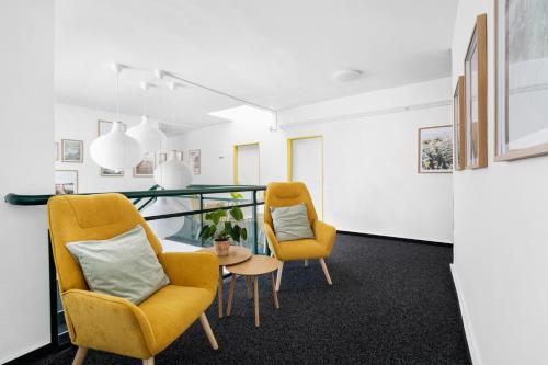 two yellow chairs and a table in a room at Penzion Village Peace #29 by Goodnite cz - U Libušky in Brno