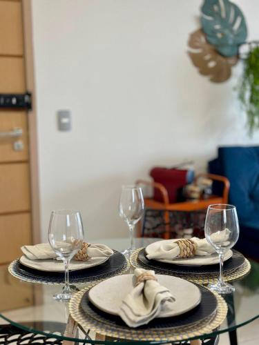 a table with two plates and wine glasses on it at (1209)Studio com vista panorâmica mar in São Luís