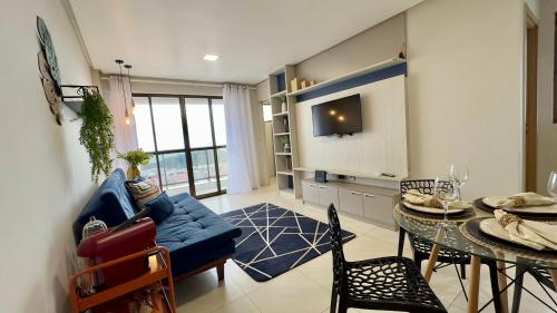 a living room with a blue couch and a table at (1209)Studio com vista panorâmica mar in São Luís