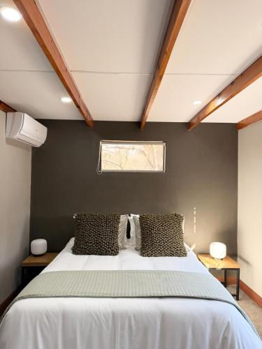 a bedroom with a large white bed with a window at Veni Vidi Amavi Luxury Safari Treehouse in Marloth Park