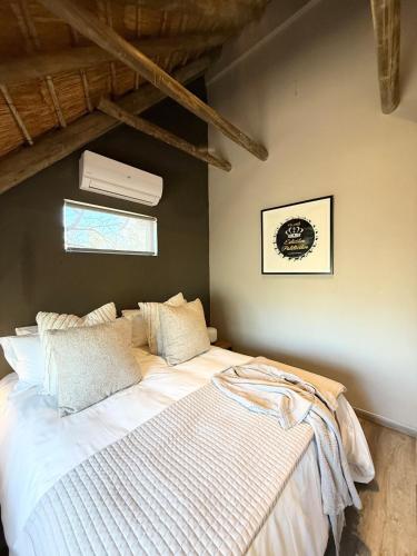 a bedroom with a large bed with white sheets at Veni Vidi Amavi Luxury Safari Treehouse in Marloth Park