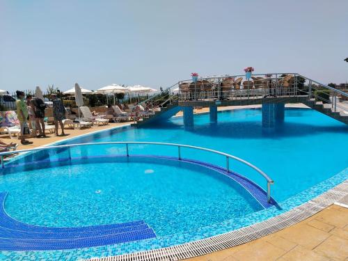 a large blue swimming pool with people on a bridge at 2 Room Apartment Costa Calma Aheloy Bulgarien in Aheloy
