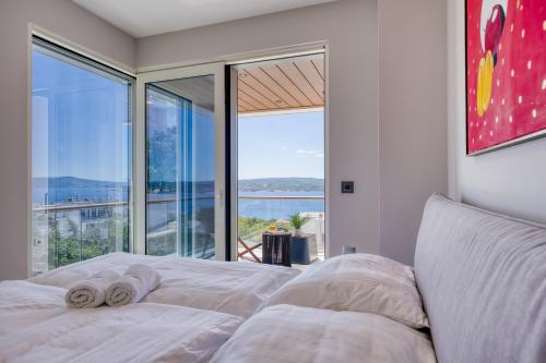 a bedroom with a bed and a large window at Villa Rosciola in Crikvenica
