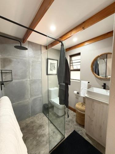 a bathroom with a shower and a toilet and a sink at Veni Vidi Amavi Luxury Safari Treehouse in Marloth Park