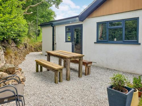 a picnic table and benches in front of a house at Ashmere in Callington