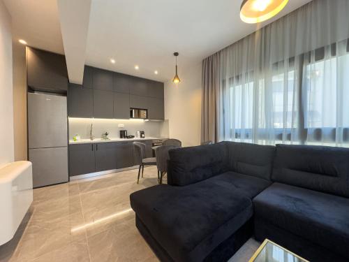 a living room with a couch and a kitchen at VILLA 8 By ProLiving Hospitality in Thessaloniki