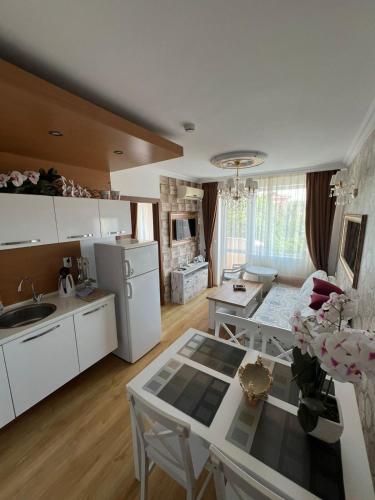 Una cocina con gabinetes blancos y una mesa en ella. en Sweet Home, en Sunny Beach