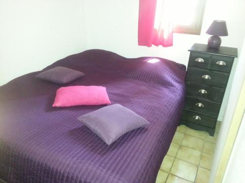 a purple bed with two pillows and a dresser at Maison, Piscine sous les pins in Moliets-et-Maa