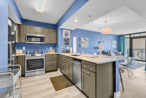 a kitchen with blue walls and a large island at 19th Floor Oceanfront - Panoramic Views - Sleeps 10 - Caribbean Resort in Myrtle Beach