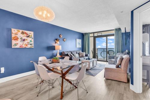 a living room with a table and chairs and a couch at Warm Winter! Indoor Hot Tub - Heated Pool - Lazy Rivers - King Bed - Gym in Myrtle Beach
