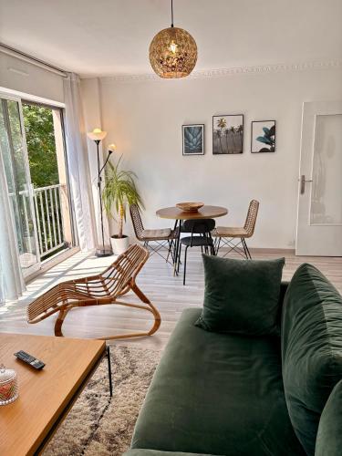un salon avec un canapé vert et une table dans l'établissement Appartement Rouen centre proche CHU, à Rouen