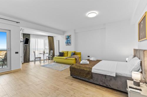 a bedroom with a bed and a living room at One SeaView std in Infinity Pool & Spa Resort in Mamaia Sat/Năvodari
