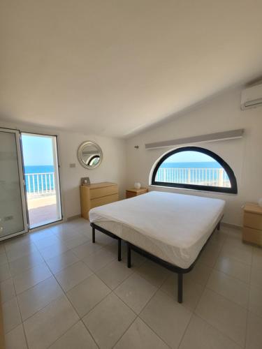 a bedroom with a bed and a view of the beach at Villa Stella in Fontane Bianche