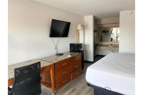 a hotel room with a bed and a tv on the wall at Motel 6 Laurel, MS in Laurel