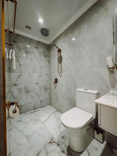 a white bathroom with a toilet and a sink at Old Yerevan Boutique Hotel in Yerevan