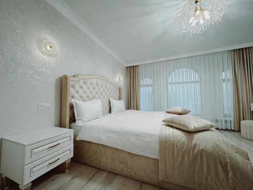 a bedroom with a large bed and a chandelier at Old Yerevan Boutique Hotel in Yerevan