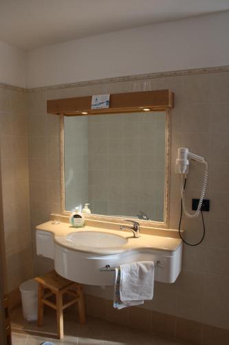 a bathroom with a sink and a mirror at La Baita in Livinallongo del Col di Lana