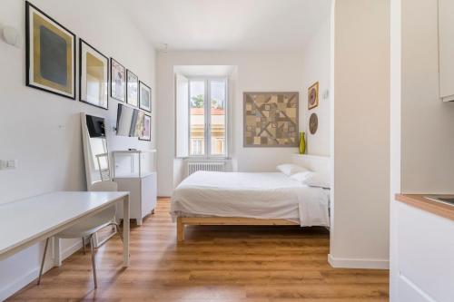 une chambre blanche avec un lit et un bureau dans l'établissement Villa Borghese, à Rome