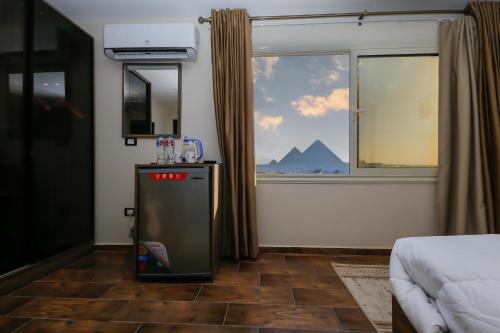 a small refrigerator in a room with a window at Rotana Pyramids View in Cairo