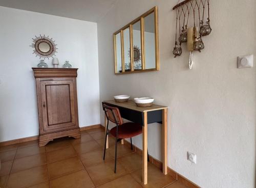 a room with a table and a chair and a mirror at Appartement Ti Balcon - Plage à 20m in Le Carbet
