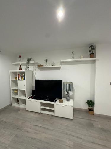 a white living room with a flat screen tv at Apartment in Palmela - Close to Beaches and Mountains! in Palmela