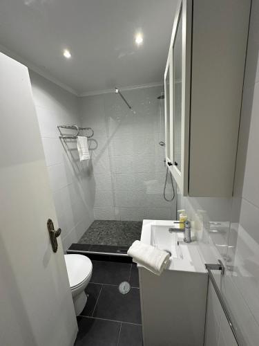 a white bathroom with a sink and a toilet at Apartment in Palmela - Close to Beaches and Mountains! in Palmela