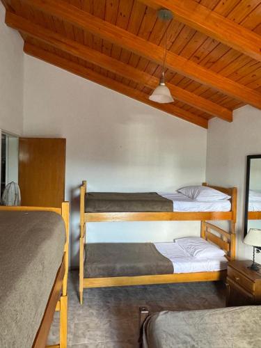 two bunk beds in a room with wooden ceilings at Casa vista panorámica al lago in Córdoba