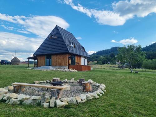 a small house with a fire pit in front of it at Deja View Cabin & Camp in Rogojel