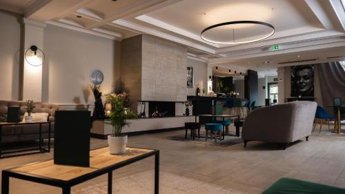a living room with a couch and a table at Logis Hôtel & Restaurant - Les Tuileries in Féy