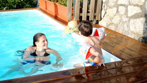 a woman and a child playing in a swimming pool at Villa Walter in Sorrento