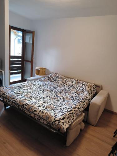 a bedroom with a bed with a flower pattern on it at Aurora Boreale studio - centro Aprica - parking in Aprica