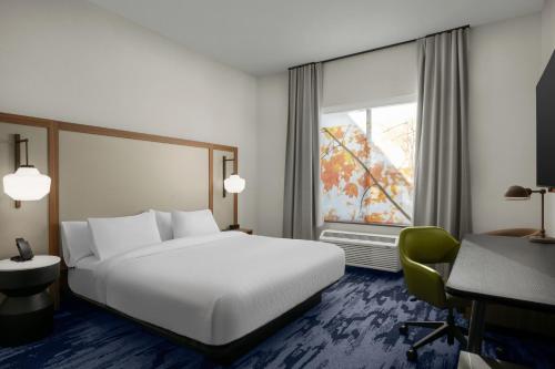 a bedroom with a bed and a desk and a window at Fairfield by Marriott Inn & Suites Kokomo in Kokomo