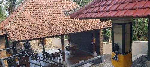 a gazebo with a roof and a table and chairs at Sunya Giri Lodge & Retreat in Sidemen