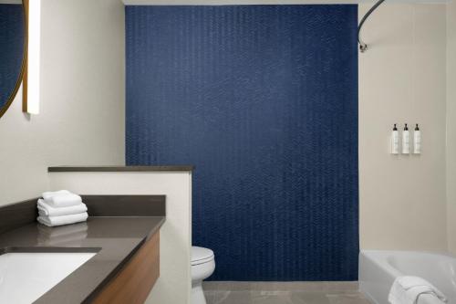a bathroom with a toilet and a blue wall at Fairfield by Marriott Inn & Suites Kokomo in Kokomo