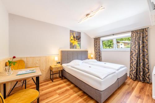 アイヒにあるHotel Kollerhofの大きなベッドと机のある寝室