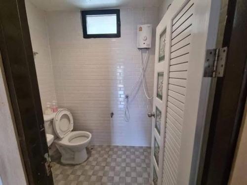 a bathroom with a toilet and a shower with a window at กัลยา รีสอร์ท in Ban Bang Saen (1)
