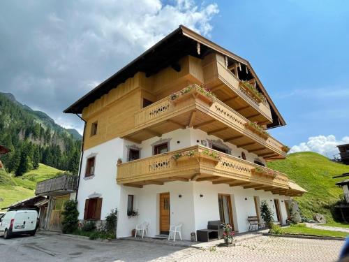 a house with a balcony on top of it at Sappada Family Apartments in Sappada