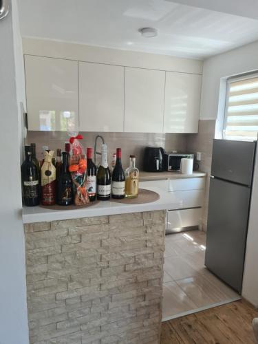 a kitchen with a counter with bottles of wine at Apartman Lozo in Višegrad