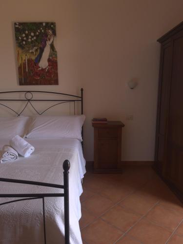 a bedroom with a bed and a painting on the wall at Agriturismo Galea in Riposto