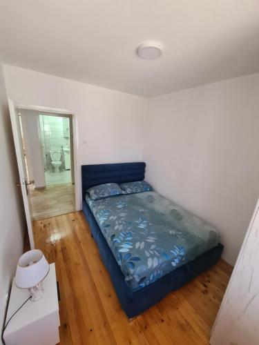 a bedroom with a blue bed in a room at Apartman Lozo in Višegrad