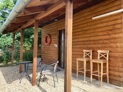 a patio with two chairs and a table next to a cabin at Csónakház in Tiszadob