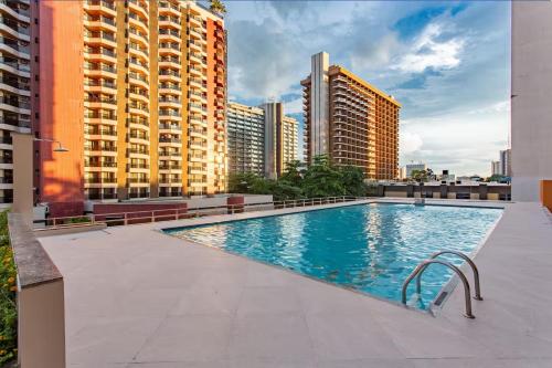a swimming pool on the roof of a building with tall buildings at Apartamento econômico Garvey Hotel in Brasilia
