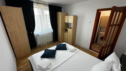 a bedroom with a white bed with blue pillows at DanubeView Apartment Tulcea in Tulcea