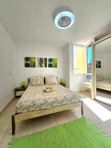 a bedroom with a bed and a green rug at El cortijo Bungalow Playa las Americas in Playa de las Americas