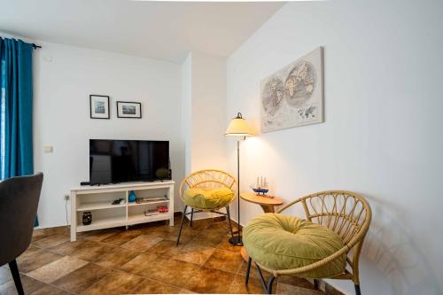 a living room with two chairs and a television at Vacation home in Budva with fantastic oceanview in Krimovice